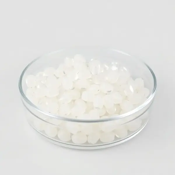 High-purity white plastic polymer pellets in a glass bowl for industrial injection molding and sustainable manufacturing.